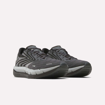 The Reebok Men's FloatZig Tread Running Shoes feature dark gray patterned mesh uppers, black laces, and a cushioned midsole—ideal for treadmill workouts—shown on a plain white background.