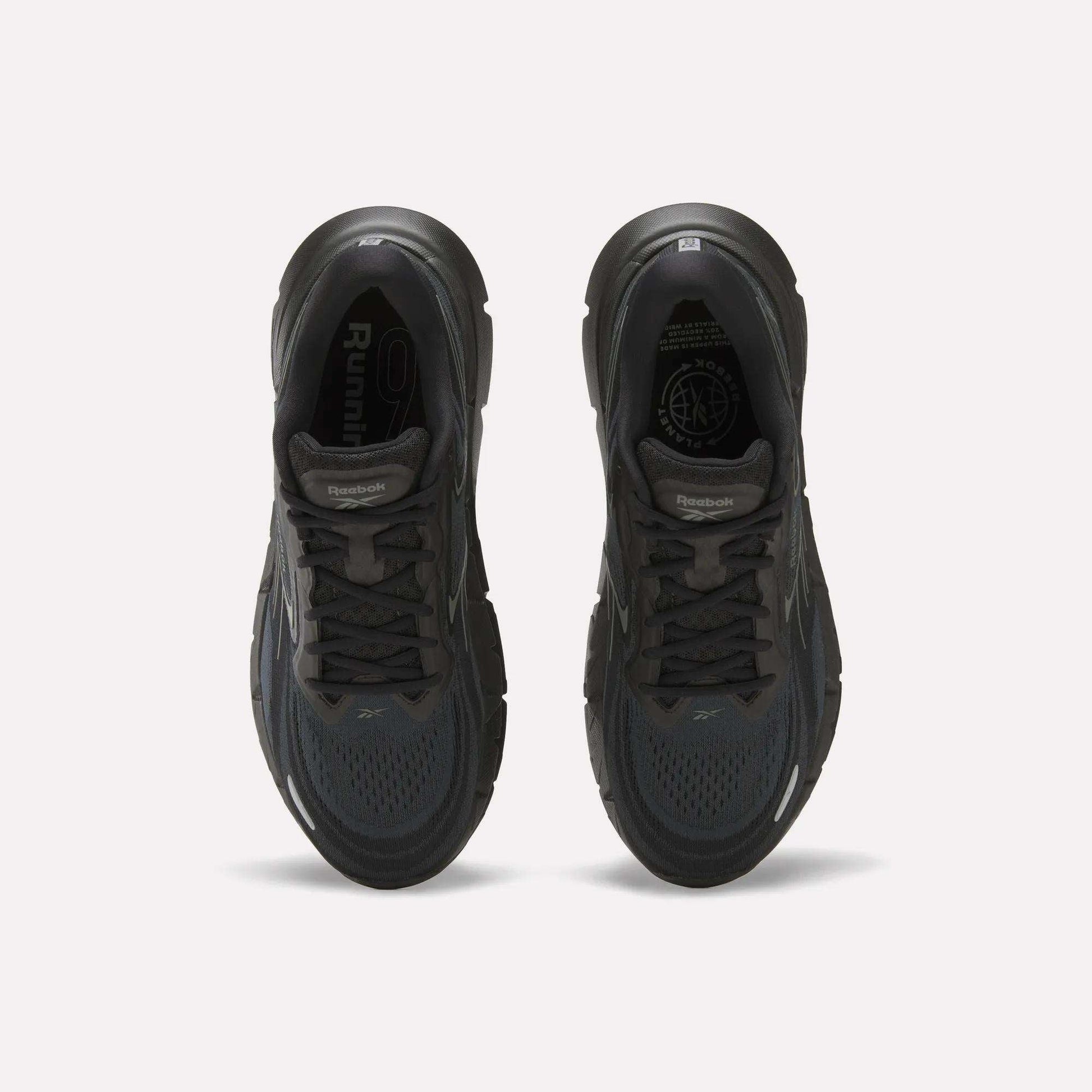 Top view of a pair of Reebok Men's FloatZig Double Running Shoes in black, featuring cushioned soles, dark laces, and mesh uppers, displayed side by side on a plain white background.