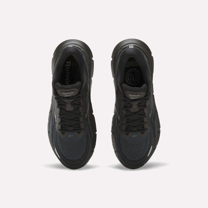 Top view of a pair of Reebok Men's FloatZig Double Running Shoes in black, featuring cushioned soles, dark laces, and mesh uppers, displayed side by side on a plain white background.