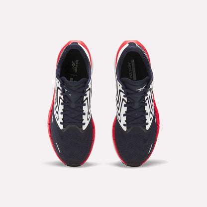 The Reebok Men's FloatZig Tread Running Shoes feature navy blue mesh toes, white patterned sides, and bright red soles—ideal for treadmill workouts. Shown from above against a plain white background.
