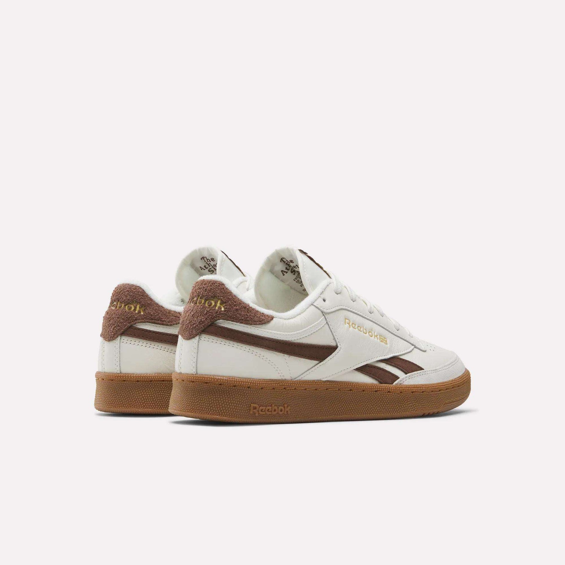 Men's Club C Revenge Vintage Shoes by Reebok—white leather sneakers with brown suede accents, gold Reebok branding, and gum rubber soles. Shown side and back on white, these sneakers offer classic vintage style.
