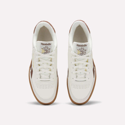 Top view of a pair of Men's Club C Revenge Vintage Shoes by Reebok, in white leather with brown soles and accents, showcasing the Reebok logo and starburst design on the tongue against a plain light background.