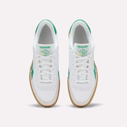 Top view of a pair of Reebok Men's Club C Revenge Vintage Shoes in white, featuring green accents, heritage branding on the tongue, and gum soles, placed side by side on a plain light background.