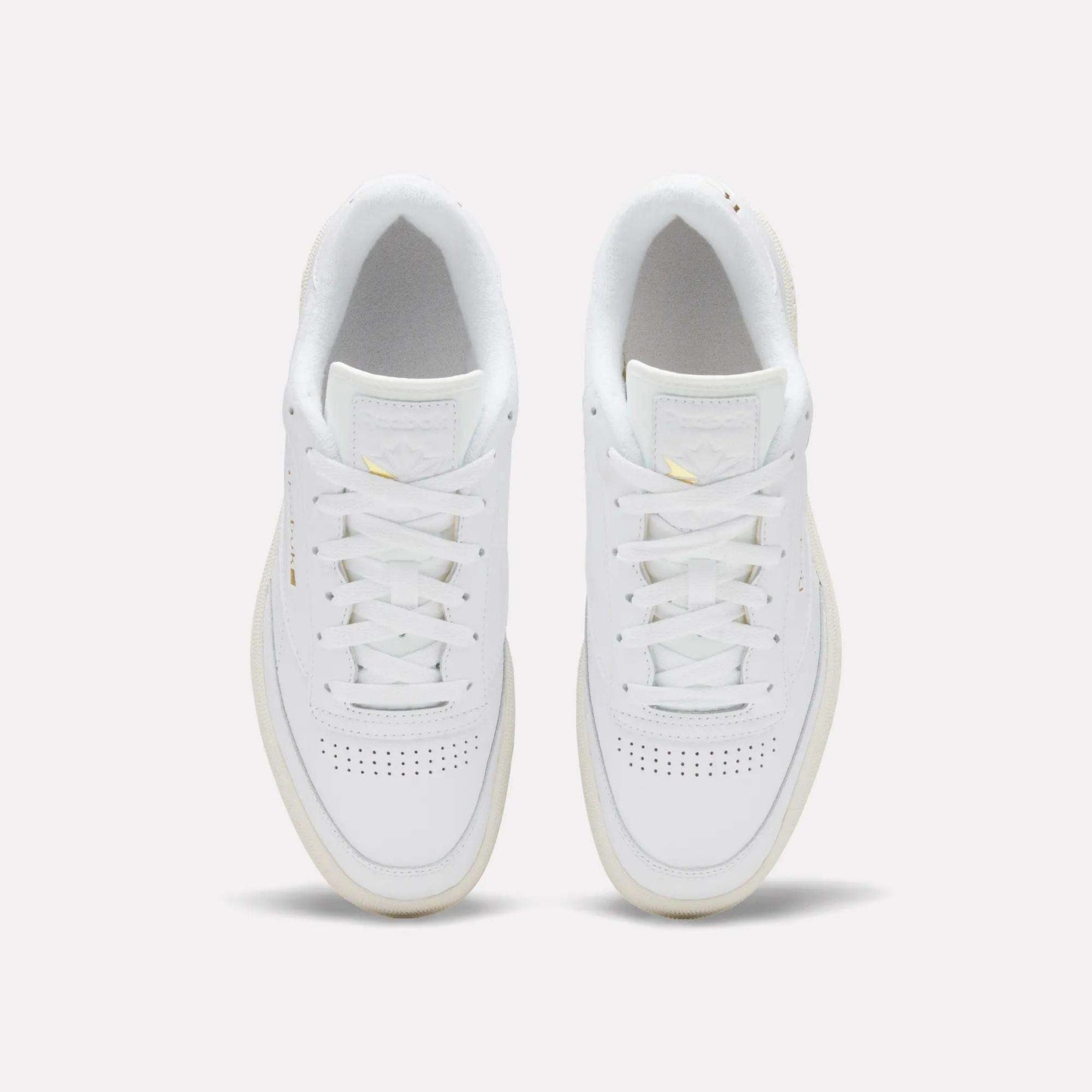 The Reebok Men's Club C 85 Shoes, crafted from premium white garment leather with white laces and subtle toe perforations, showcase the timeless style of a classic sneaker against a light background.