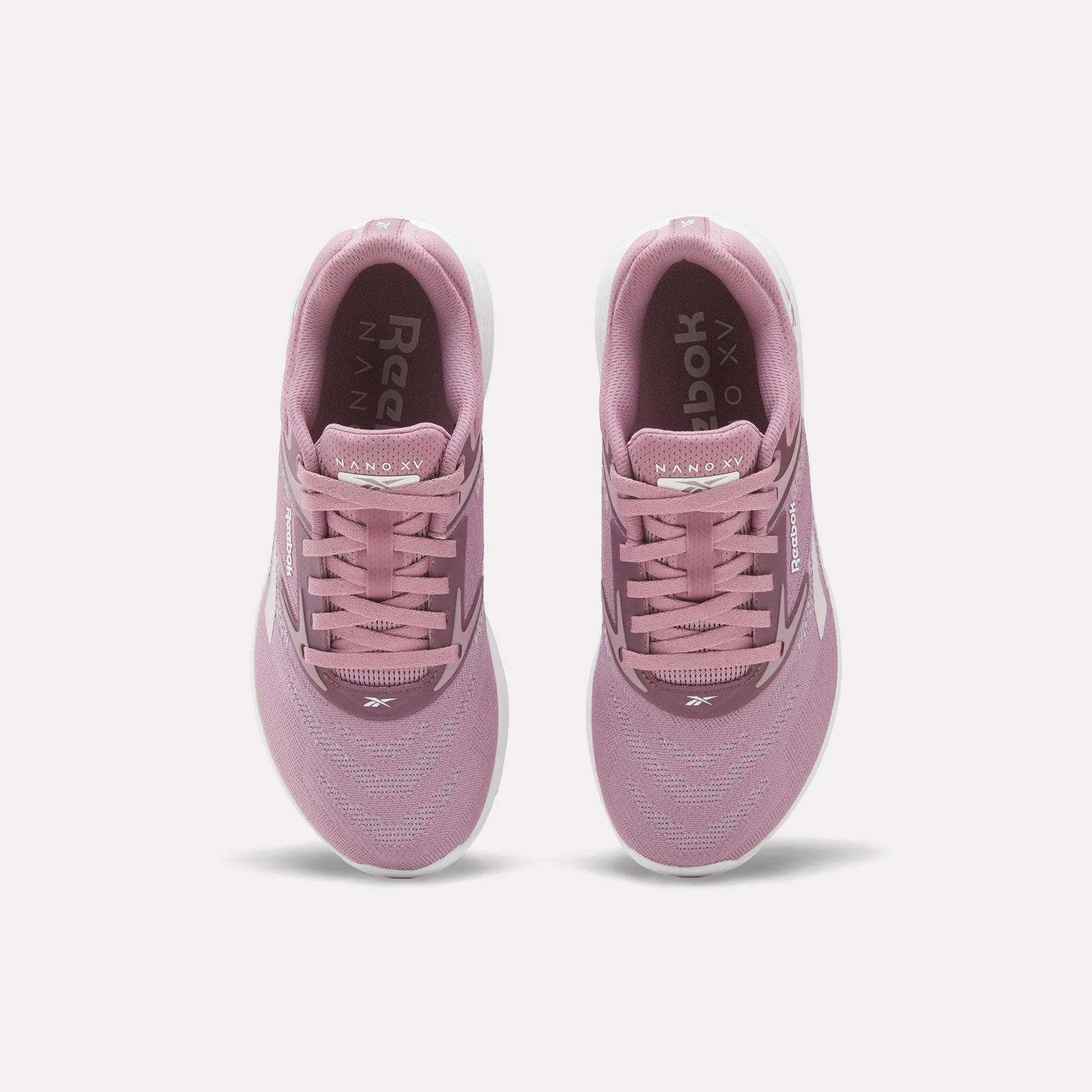 A pair of Reebok Nano X5 Women's Training Shoes in pink, viewed from above with visible laces, mesh upper, dual-density midsole, and white soles on a plain white background—ideal for stylish support during training.