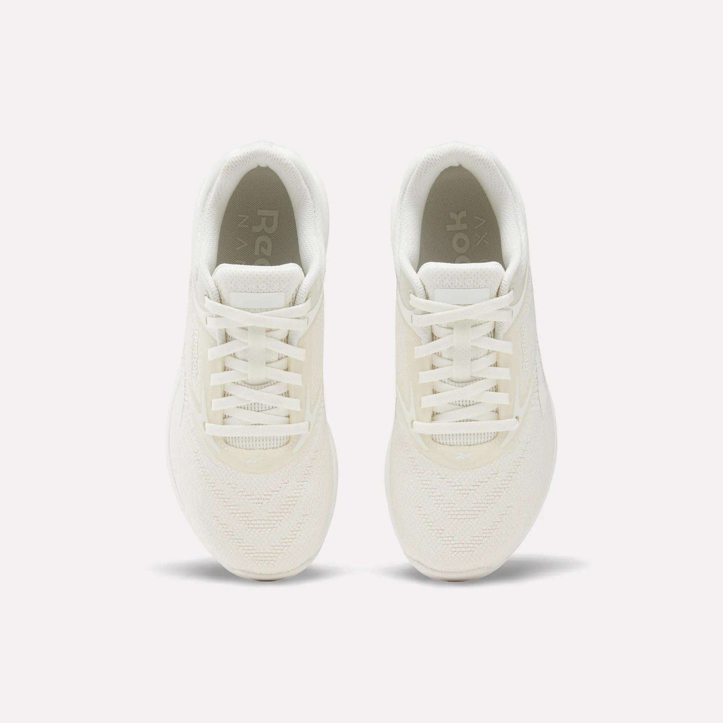 The Reebok Nano X5 Women's Training Shoes, shown from above on a plain white background, highlight their white color, laces, mesh texture, and soles.