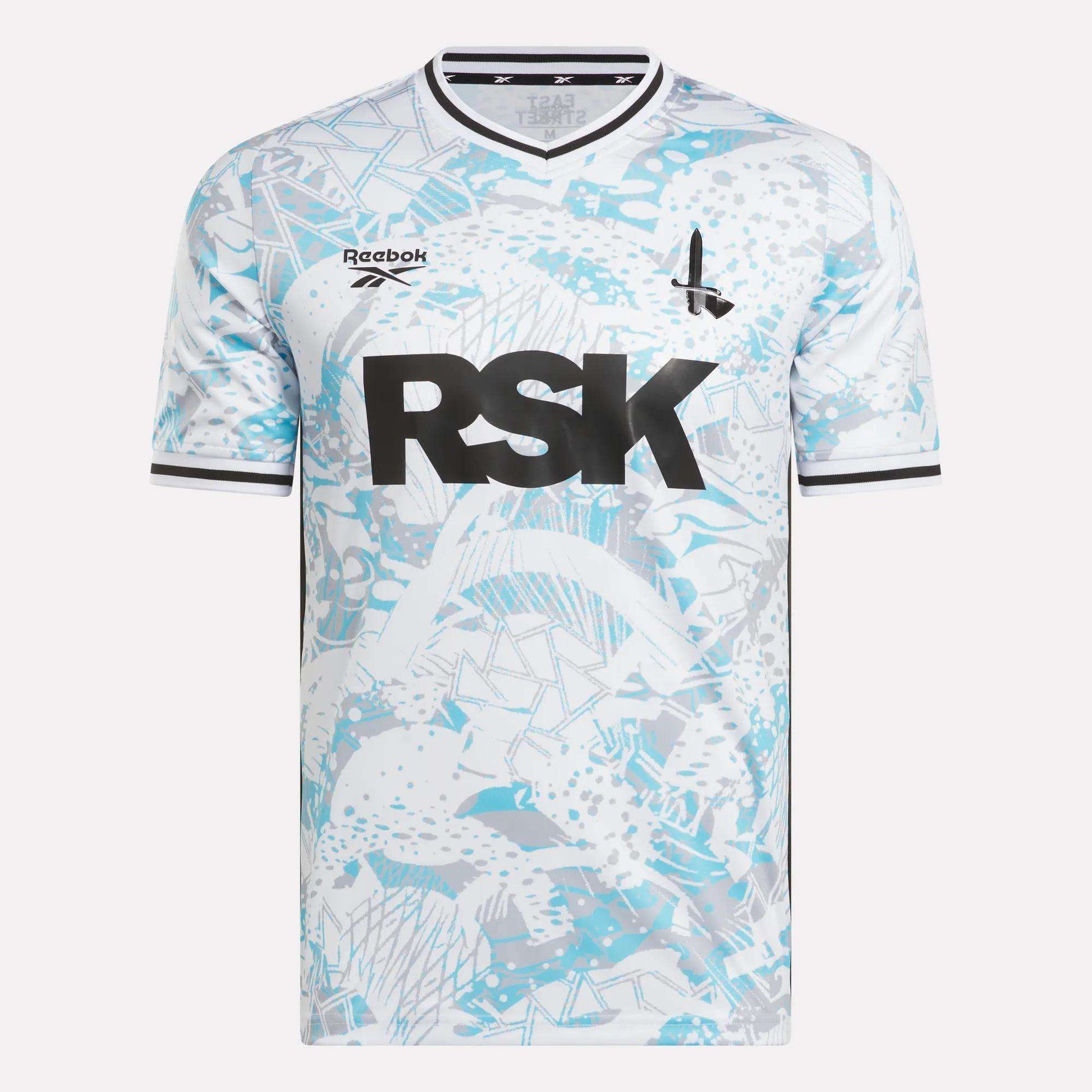 The Men's Charlton Away Jersey by Reebok features a white and light blue fish scale pattern, black trim, bold RSK lettering, a small rocket ship graphic, and Addicks pride.