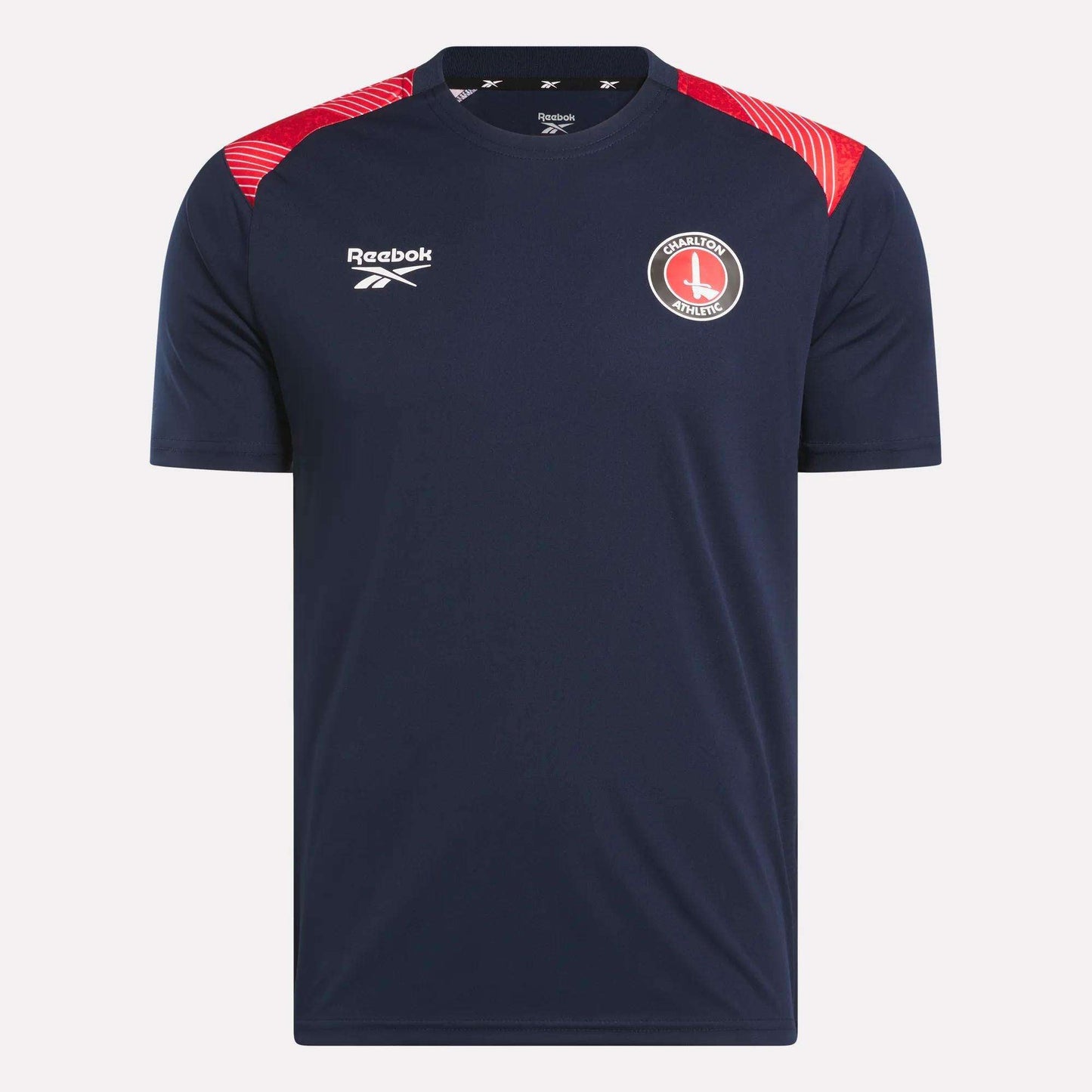 The Men's Charlton Training T-Shirt by Reebok features navy blue fabric, red shoulder details, a white Reebok logo on the right chest, and the Charlton Athletic crest on the left—perfect for devoted Charlton fans.