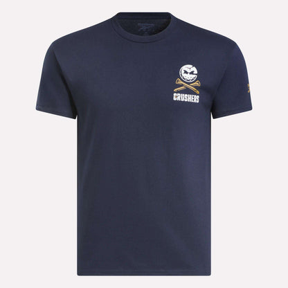 The Men's Crushers Stacked Logo Tee by Reebok is a navy short-sleeve shirt featuring a small white baseball and crossed bats graphic above “CRUSHERS” on the left chest, inspired by Bryson DeChambeau’s team spirit.