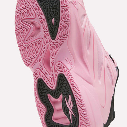 Close-up of the pink and black sole of the Reebok Angel Reese 1 Shoes for big kids, showcasing textured patterns, grooves, and a visible Reebok logo—highlighting the shoe’s grip and standout design details. Perfect for young players seeking performance and style in their basketball shoes.