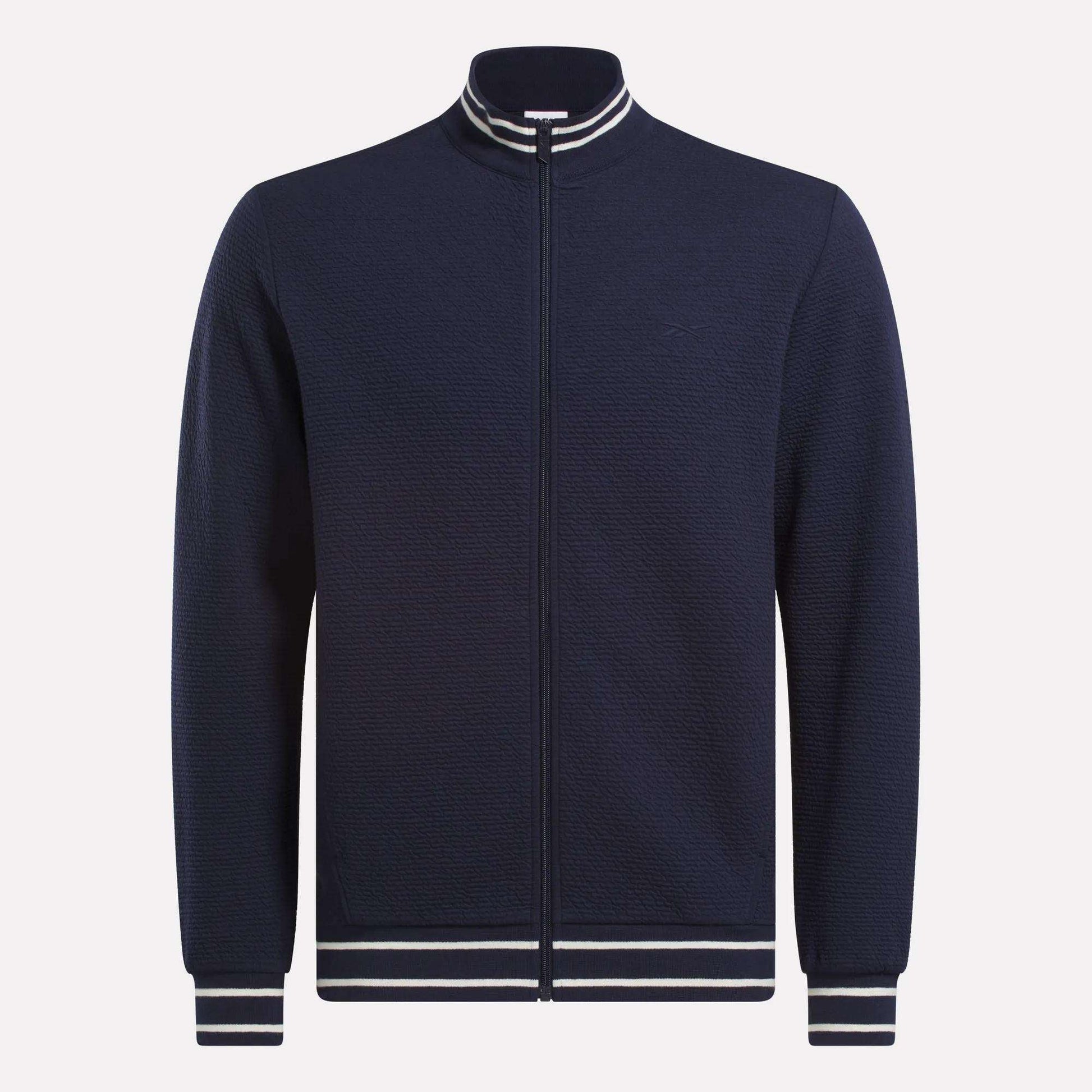 The Reebok Men's Club Sport Textured Jacket is a navy zip-up with thermal knit fabric and white/navy striped ribbed collar, cuffs, and hem, shown on a plain white background.