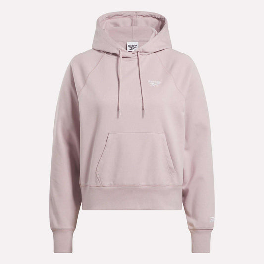 The Women's Small Vector Cropped Hoodie by Reebok comes in light pink French terry, featuring a front pocket, drawstrings, and white logos on the chest and sleeve. Shown against a plain white background.