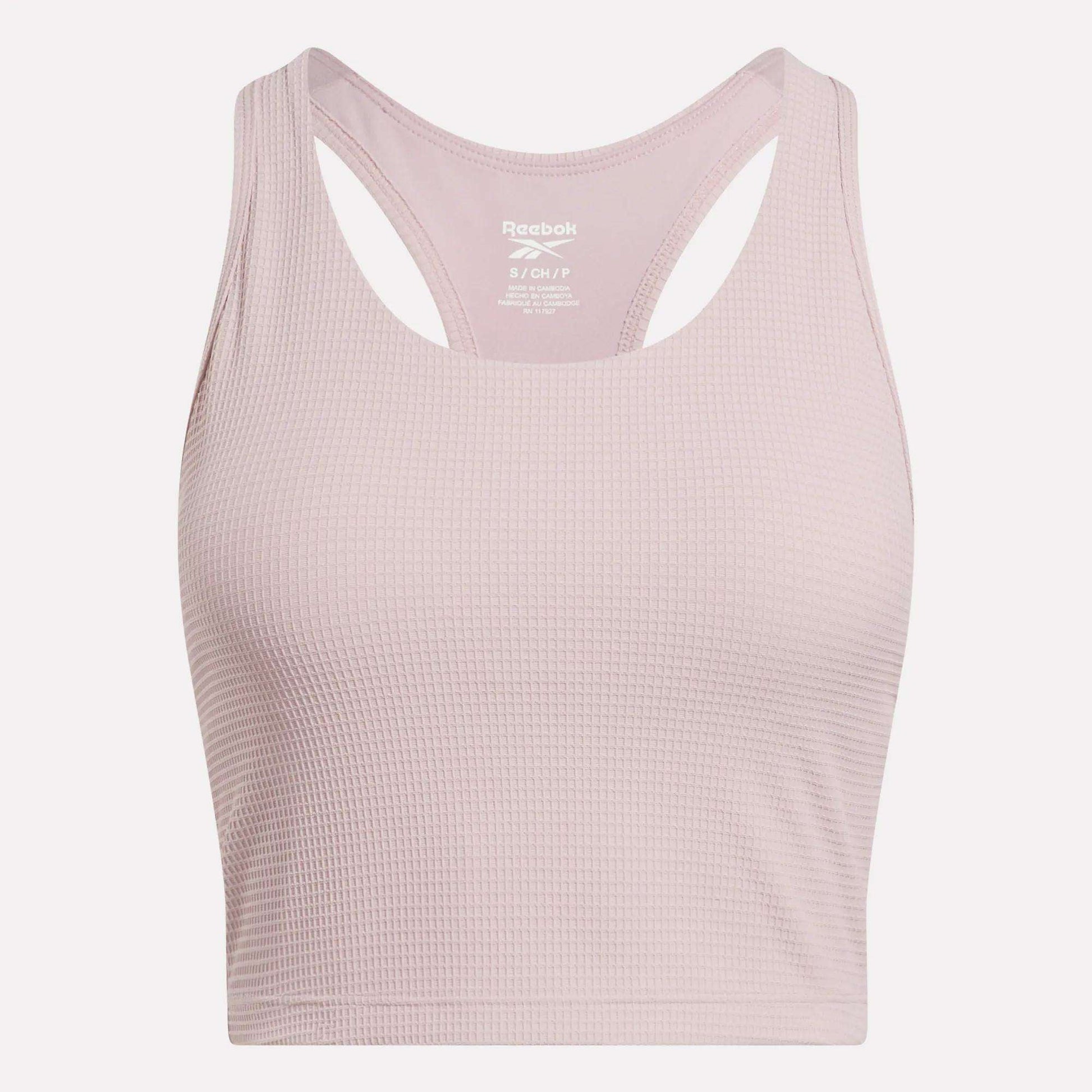 The Reebok Women's Time Out Cropped Tank Top in light pink features a ribbed pattern and racerback design—perfect for stylish activewear. Shown against a plain white background.