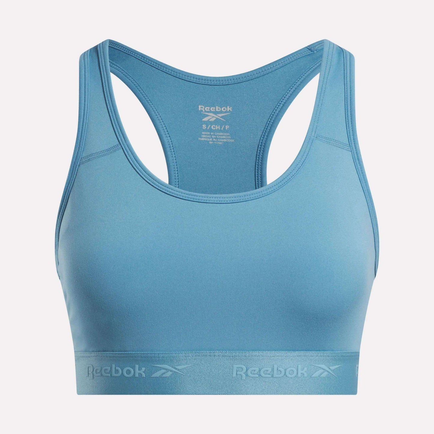 Women's Medium-Impact Sports Bra by Reebok in light blue, featuring a racerback design and an elastic band with the Reebok logo printed on it. This medium-impact sports bra includes removable cups for customizable comfort, and the inner tag provides size and care instructions.