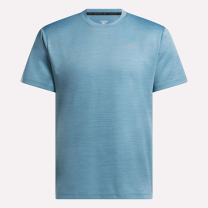 The Reebok Men's Director Short Sleeve Top is shown in light blue against a plain white background. This stretchy training tee has a simple design with a small left chest logo, ideal for everyday workouts.