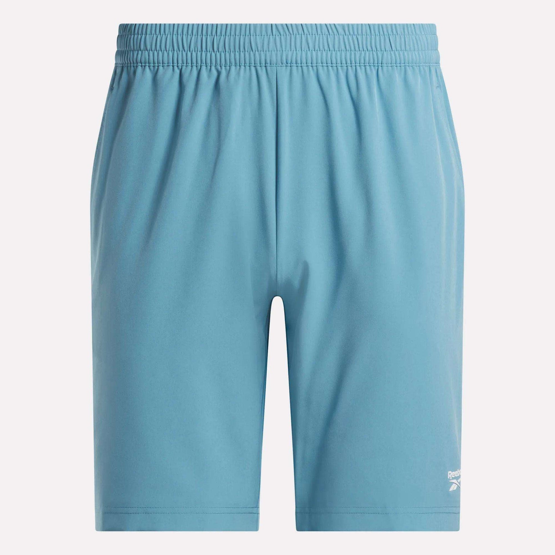 Men’s Range Shorts 9" by Reebok in light blue, featuring an elastic waistband and a small white Reebok logo on the lower left leg; these performance shorts are showcased against a plain white background.