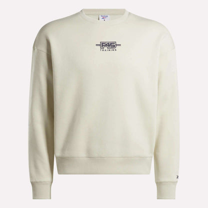 The Reebok x F45 Training Relaxed Graphic Sweatshirt features a cream color, dark F45 TRAINING and barbell logo on the chest, long sleeves, and a relaxed fit—ideal for post-workout lounging.