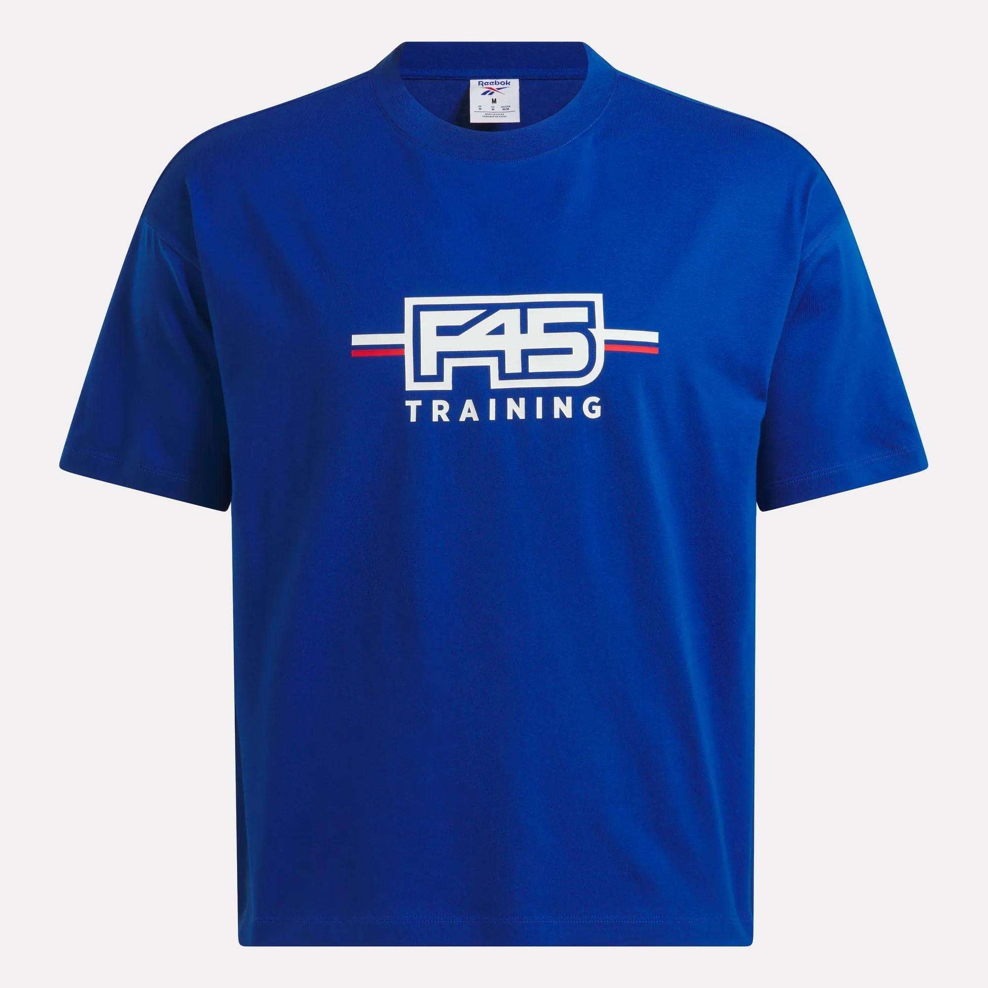 The Reebok x F45 Training Graphic T-Shirt showcases the iconic F45 TRAINING logo in white, red, and blue at the center of a blue short-sleeve design. Created in collaboration with Reebok, this tee blends athletic style with everyday comfort.