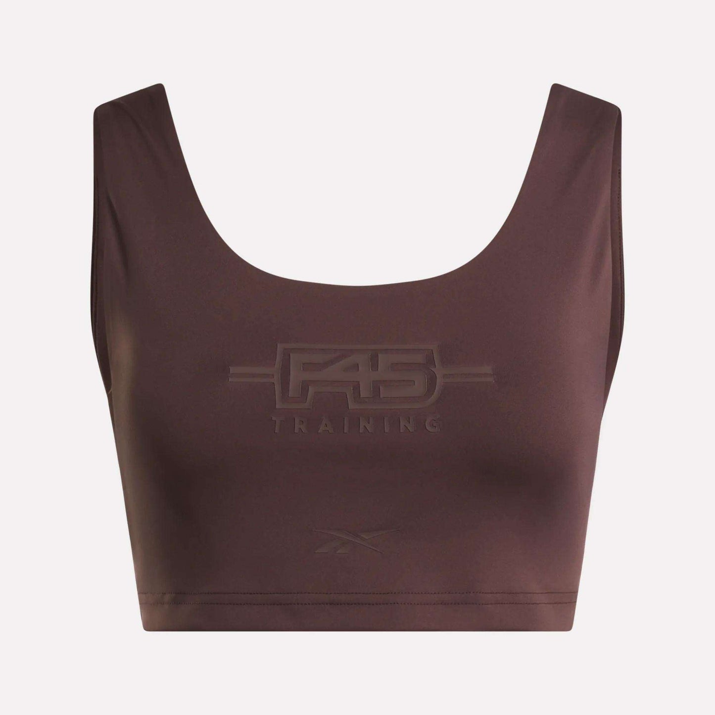 Introducing the Women's Reebok x F45 Training Sports Bra. This brown sports bra by Reebok features "F45 Training" embossed on the front, with a subtle Reebok logo beneath. Designed with a scoop neckline and wide shoulder straps, it stands out against a plain background to keep the focus on the garment.