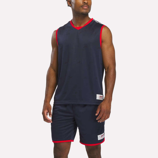 A man wears the Reebok Men's United Jersey Tank in Vector Navy, standing against a plain white background.