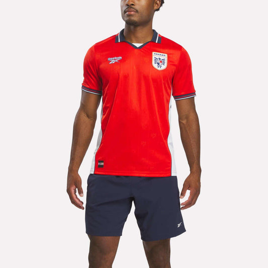 A person wearing a red Reebok Men's Panama Home Jersey stands against a plain white background.