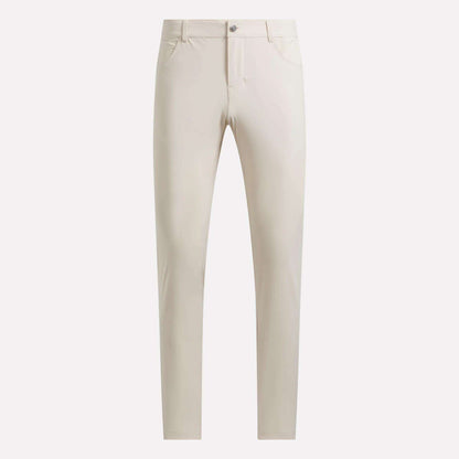 A pair of Reebok Men's Favorite 5-Pocket Relaxed Fit Golf Pants in beige or off-white, showcased against a plain white background. Made with RBK-DRY fabric, these wrinkle-resistant pants include front pockets and a button closure.