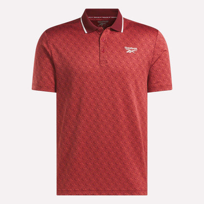 Men's Jacquard Polo Shirt by Reebok in red, featuring a subtle geometric jacquard pattern, short sleeves, and a classic collar with stylish white trim. Finished with the white Reebok logo on the left chest.