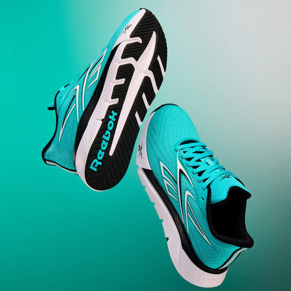 Turquoise Reebok Nano Gym 2.0 training and running shoes on a gradient green background