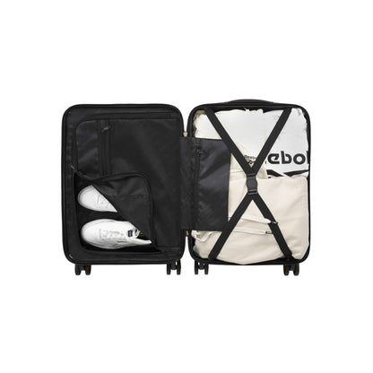 An open Captain 2 Piece Luggage Set by Reebok displays neatly packed items: two white sneakers in a zippered pocket, folded clothes strapped in, and a black interior. The durable luggage set comes with convenient spinner wheels.