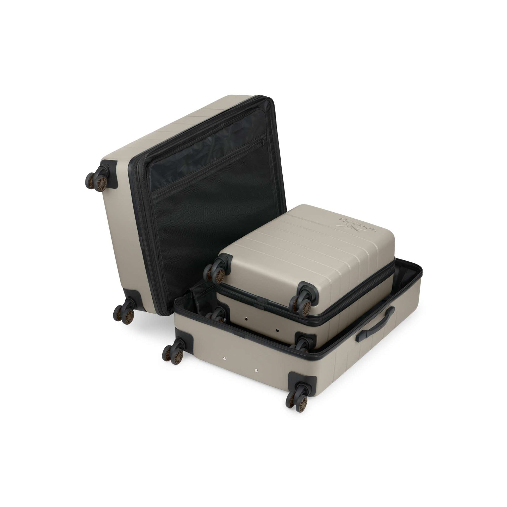 The Reebok Captain 2 Piece Luggage Set includes two beige hard-shell suitcases, one nested inside the other, both with black interiors, spinner wheels, and a durable design, shown on a white background.