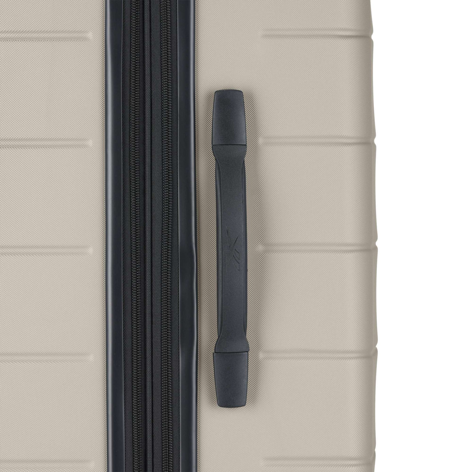 A close-up of a beige hard-shell suitcase from the Reebok Captain 2 Piece Luggage Set features a black side handle, black zipper, horizontal ridges, and durable luggage construction.