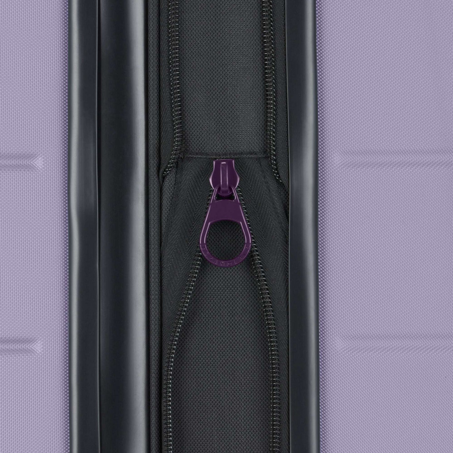 Close-up of a purple zipper pull on a black zipper, set against textured purple—part of the Reebok Captain 2 Piece Luggage Set, known for durability and smooth spinner wheels, ideal for travel.
