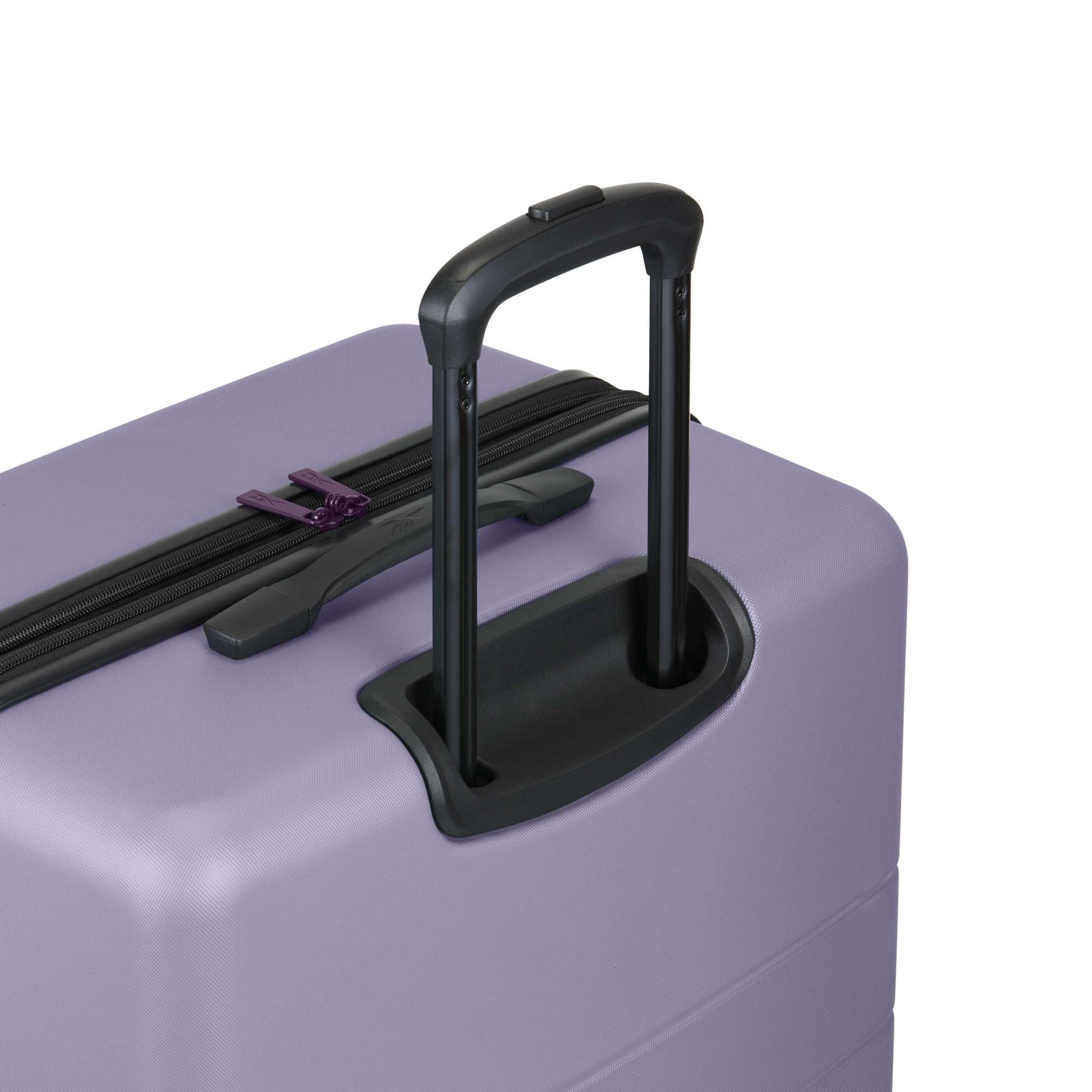 A close-up of the Reebok Captain 2 Piece Luggage Set in purple shows its durable hard-shell design, black retractable handle, spinner wheels, and a visible top zipper.