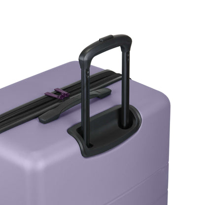 A close-up of the Reebok Captain 2 Piece Luggage Set in purple shows its durable hard-shell design, black retractable handle, spinner wheels, and a visible top zipper.