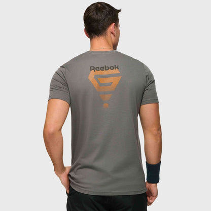 A man faces away, wearing the Reebok x GLDN PNT Jersey Tee by Reebok, featuring an orange geometric design and logo on the back. Paired with black shorts and wristband, it's a minimalist choice for everyday wear.