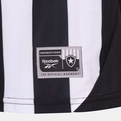Close-up of a black and white striped Kids' Botafogo Youth Home Jersey by Reebok, featuring a rectangular patch with the star emblem and text: "DESIGNED IN THE BFR" and "THE OFFICIAL GARMENT.
