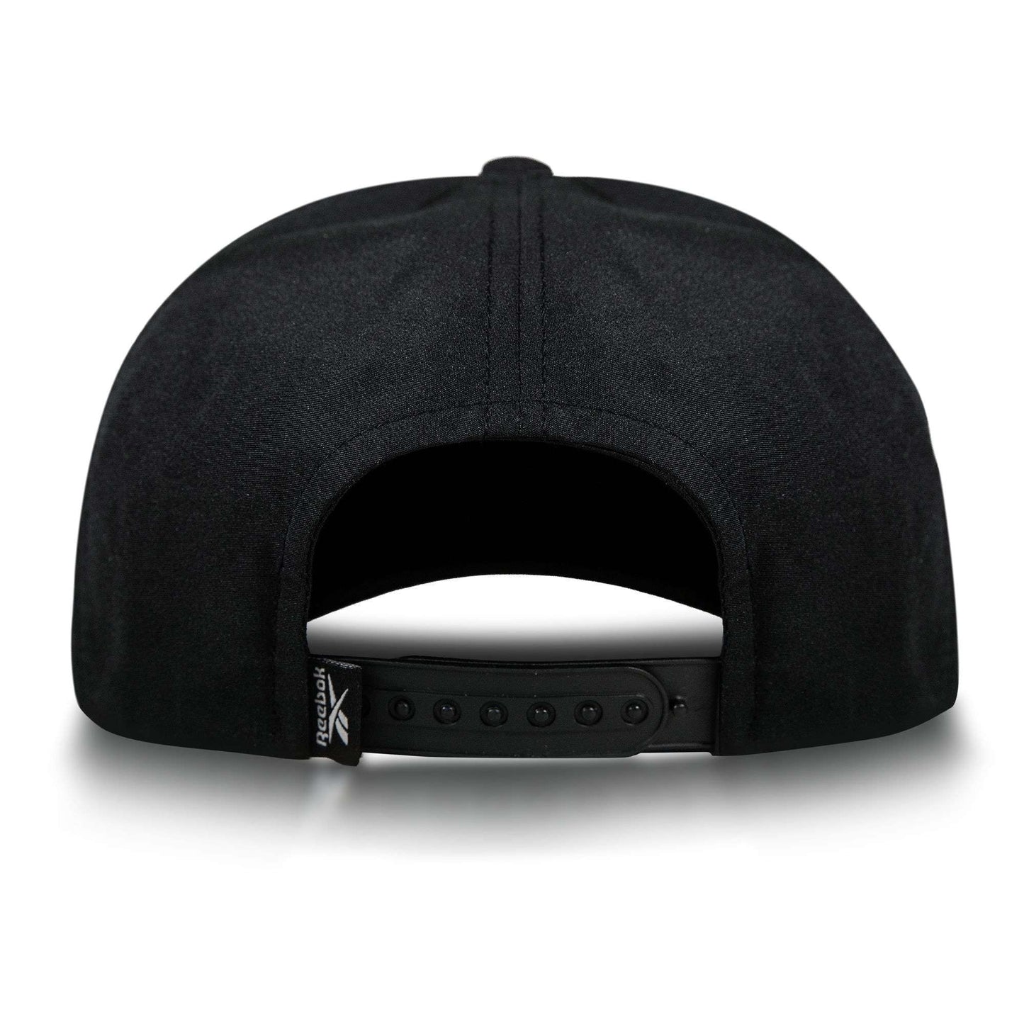 The Reebok Madison Ii is a black recycled polyester hat with an adjustable snapback closure and a small folded tag featuring the Reebok logo on the left side, viewed from the back.