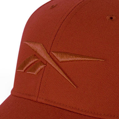 A close-up of a rust-colored Reebok Vector Baseball Cap showcases the embroidered front logo and adjustable snapback closure for a perfect fit.