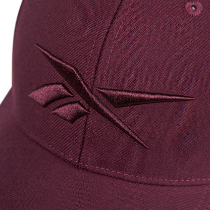 Close-up of the Reebok Vector Baseball Cap in maroon, featuring a maroon embroidered Reebok logo on the front.