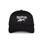 The Reebok Logo Cap is a black cotton twill cap with the Reebok logo and name embroidered in white on the front panel, featuring an adjustable buckle closure for comfort.