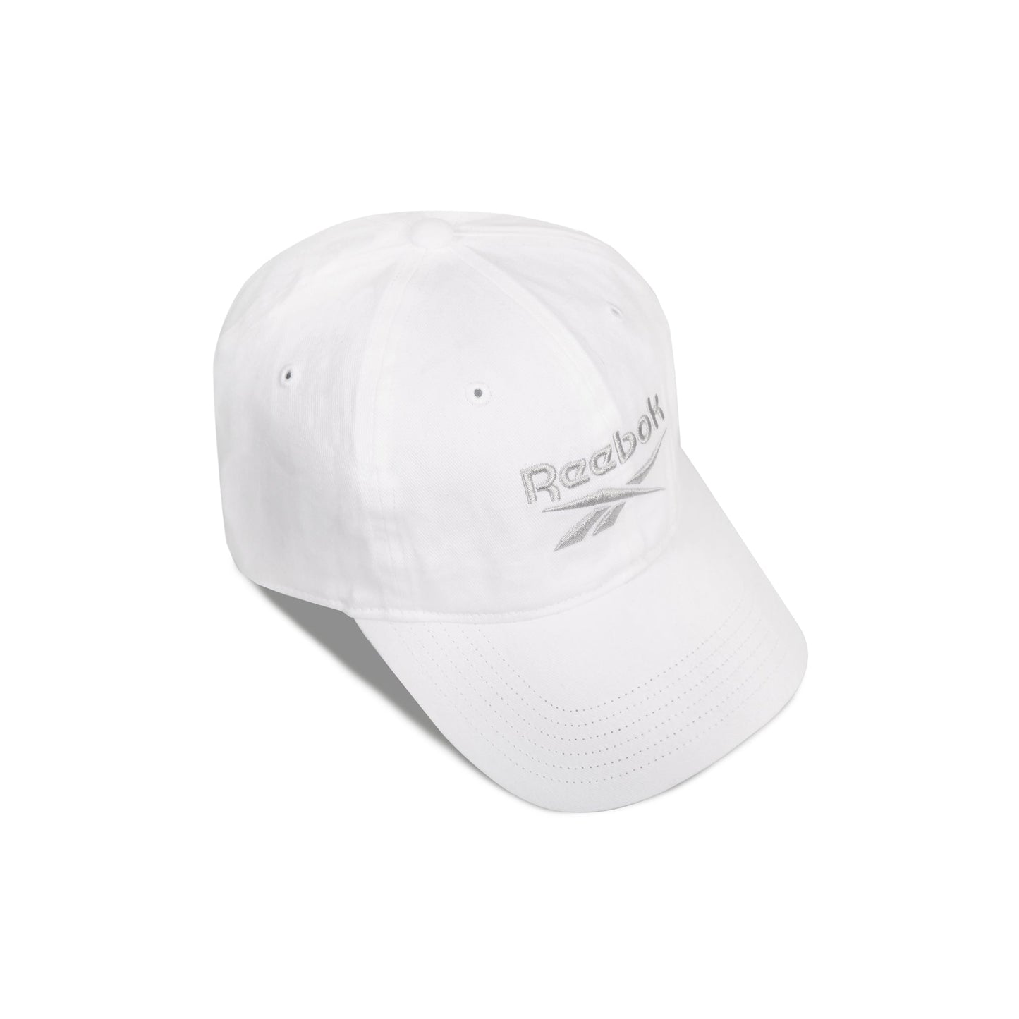The Reebok Logo Cap is a white cotton twill cap with a curved brim, silver embroidered logo and vector on the front, and an adjustable buckle closure, shown against a white background.