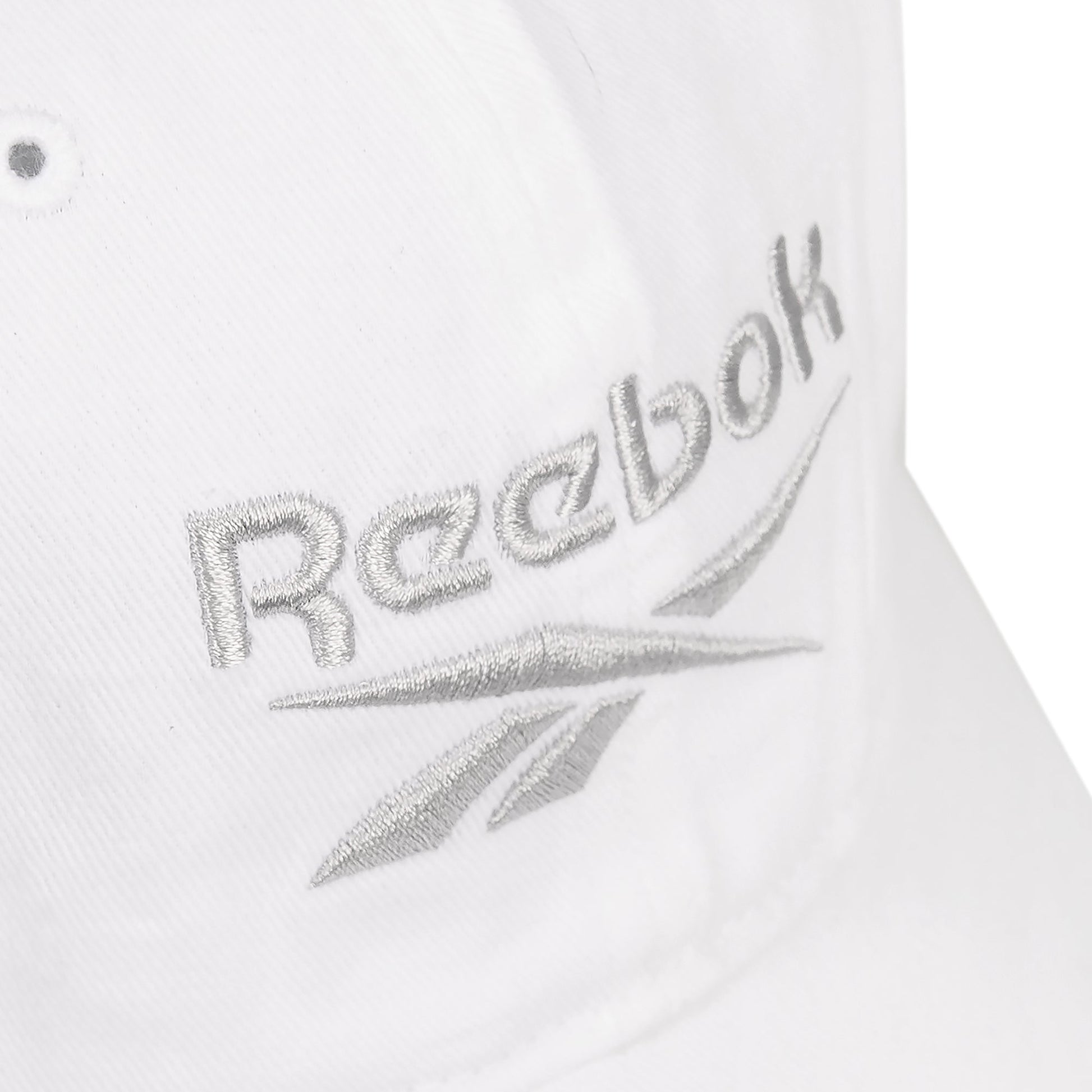 Close-up of the Reebok Logo Cap, crafted from cotton twill with silver embroidered text on the front and an adjustable buckle closure for a perfect fit.