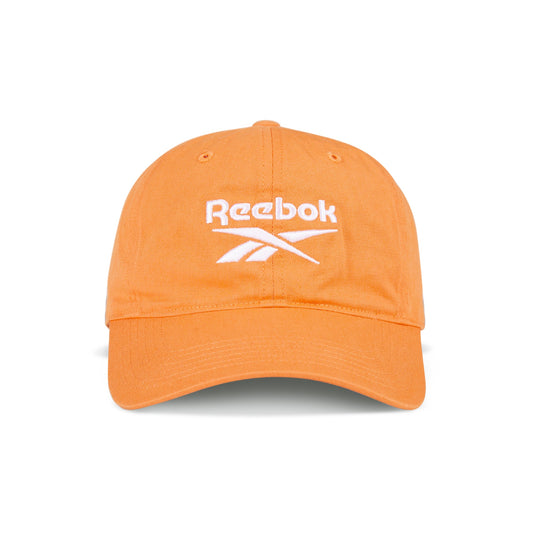 The Reebok Logo Cap features bright orange cotton twill, a curved brim, and a white embroidered logo on the front. It has an adjustable buckle closure for a custom fit and is shown against a white background.
