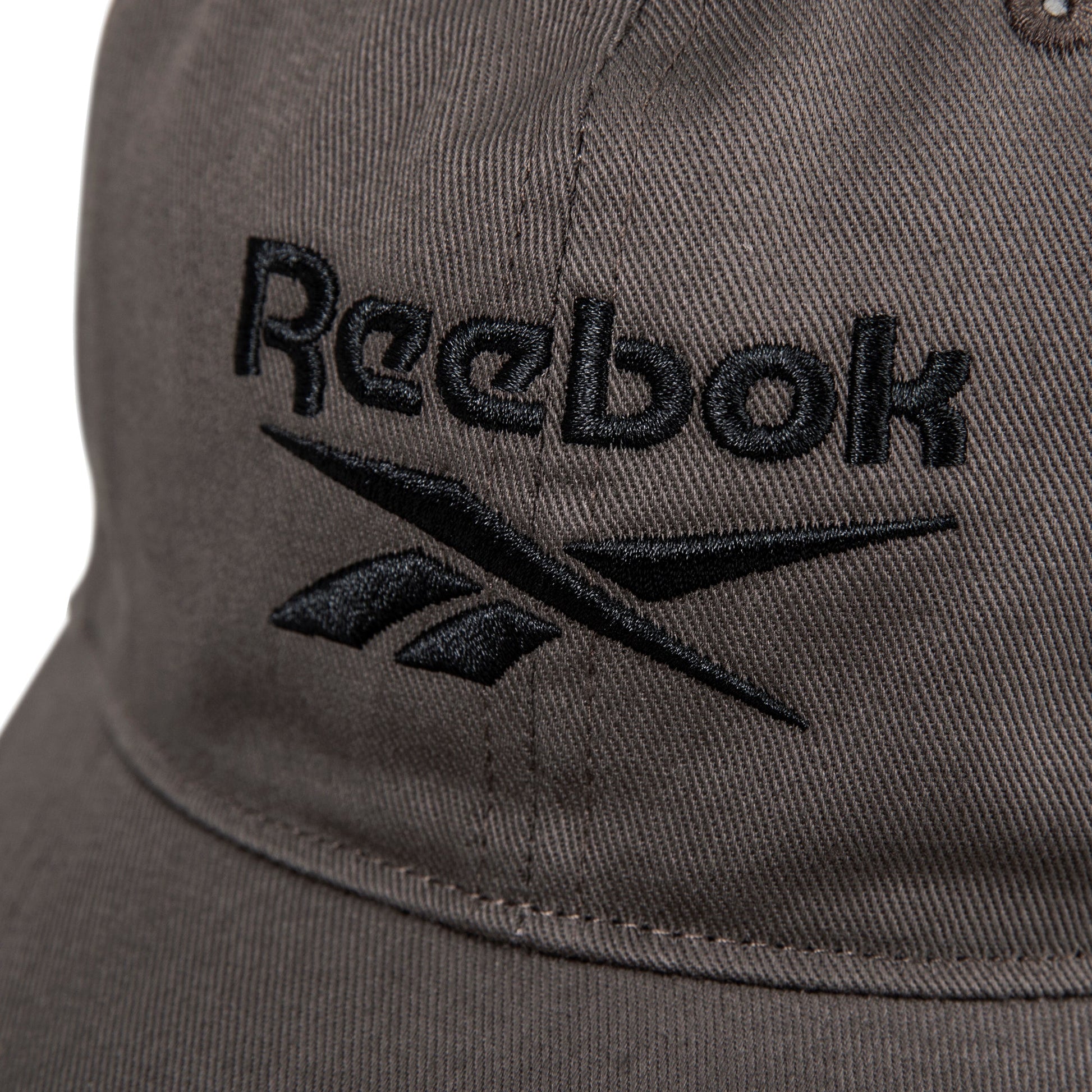 Close-up of the Reebok Logo Cap— a brown fabric baseball cap with the black embroidered Reebok logo and name on the front.