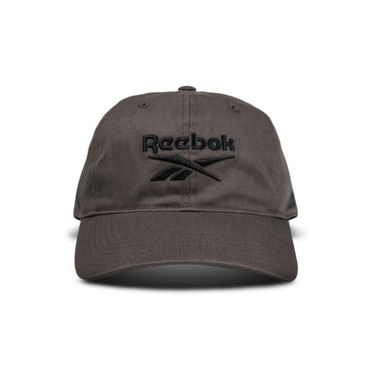 A dark gray Reebok Logo Cap with a black embroidered logo and text on the front is displayed from the front against a white background.