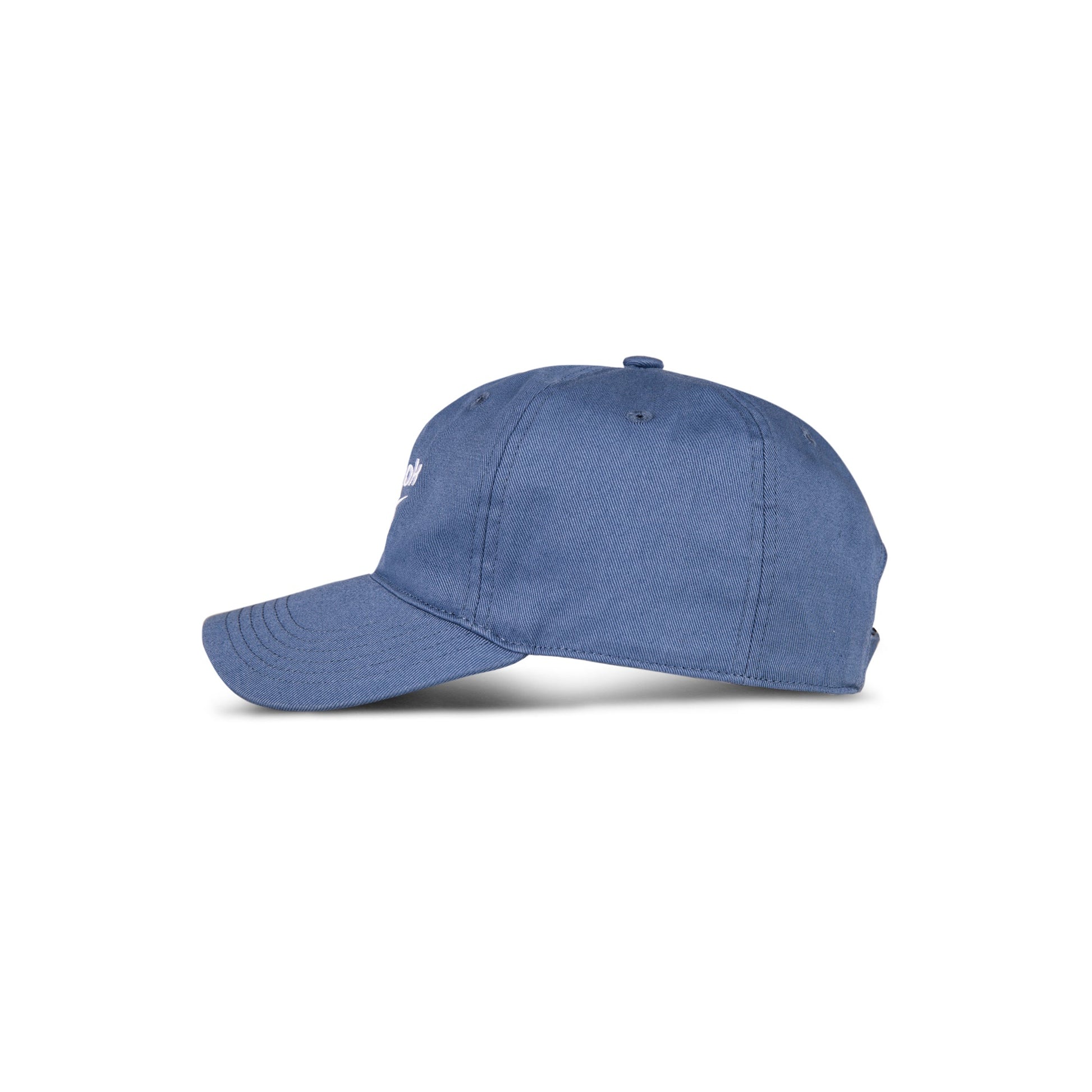 A blue Reebok Logo Cap made from cotton twill is shown side-on against a white background, featuring a curved brim, top button, and an adjustable buckle for a custom fit.