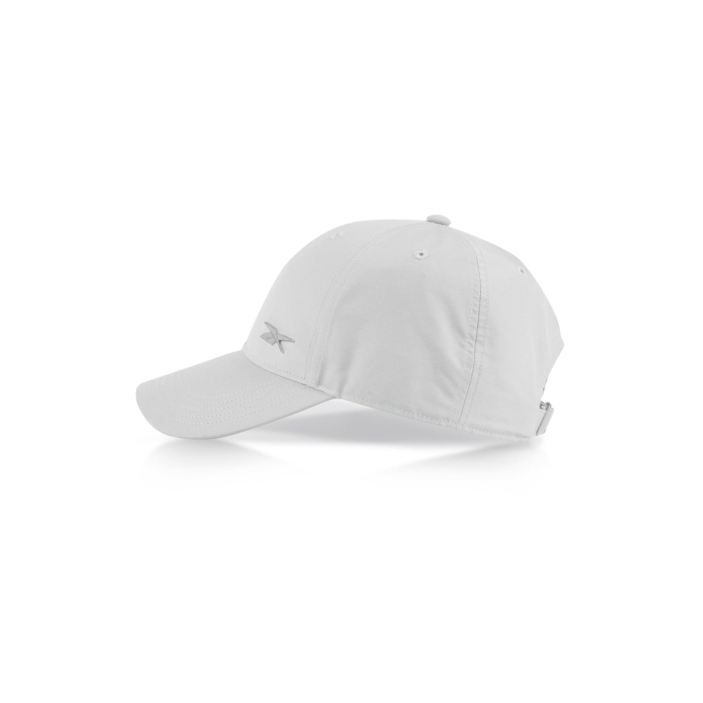 The Reebok Badge Cap is a plain white adjustable sports cap with a curved brim, ventilation holes on top, and a subtle front-left logo. Shown against a white background.
