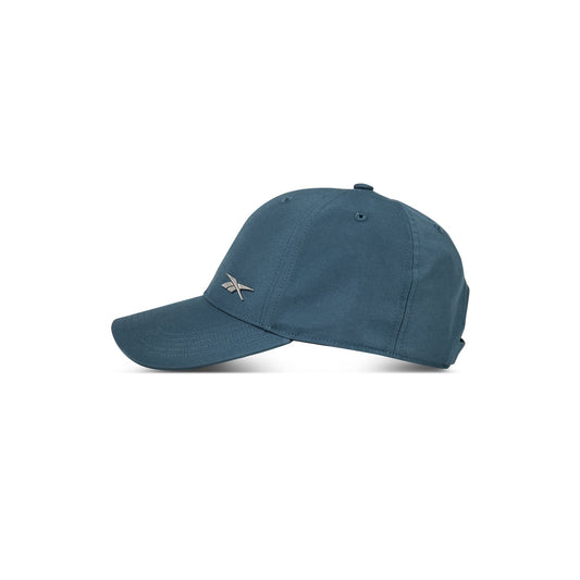 The Reebok Badge Cap in teal blue features a curved brim and a small silver logo on the front. Shown in profile on a white background, this adjustable cap delivers comfort and style for any activity.