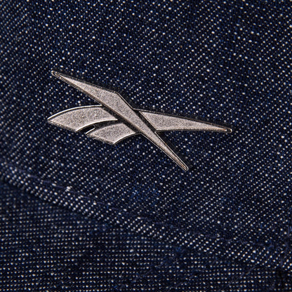 A metallic Reebok logo pin accents the textured blue Denim Badge Cap by Reebok, giving it a stylish edge.