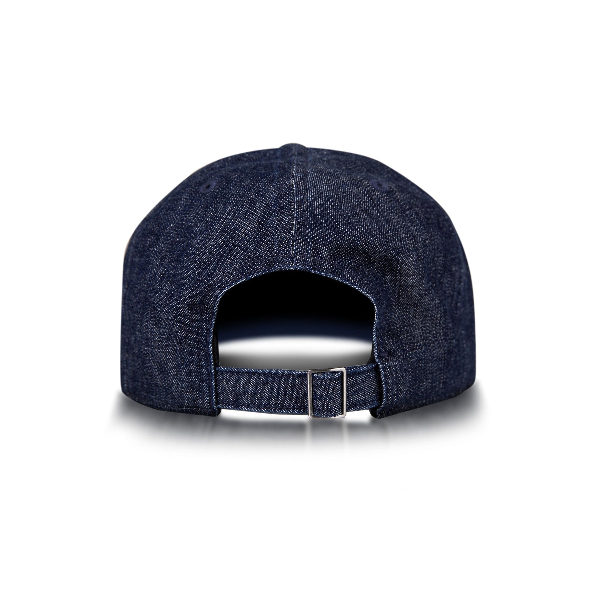 The Reebok Denim Badge Cap is shown from the back with an adjustable strap, metal buckle, and Speedwick sweatband. This dark blue cap appears on a white background with a subtle shadow beneath it.